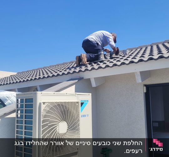 אדם עובד על גג עם מערכת מיזוג אוויר